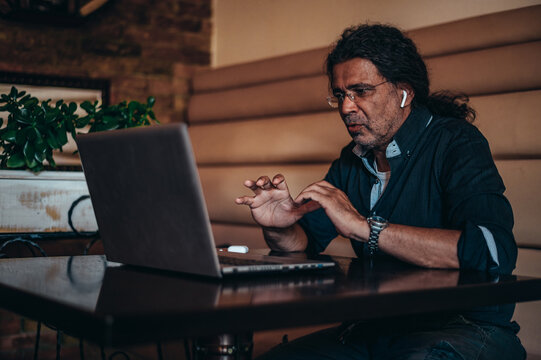 Senior hispanic cuban men using a laptop for an online meeting - Powered by Adobe