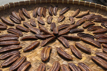 Sale pisang is an Indonesian traditional banana snack that is sliced and laid out in the sun to dry. A group of dried sliced bananas on a container called 