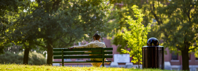 Man in a hat sitting on a park bench  alone