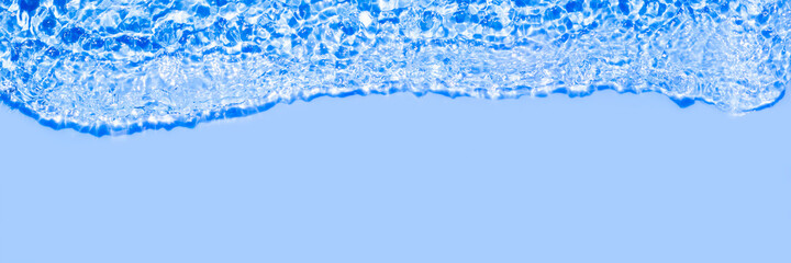 Serum texture close up. Clear blue liquid gel background. Transparent beauty skincare product sample. Cosmetic clear liquid cream smudge. Transparent skin care long banner with copy space
