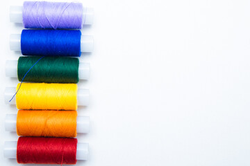 Skeins with threads are lined up in a row according to the color of the rainbow. top view, flat lay, copy space, isolate