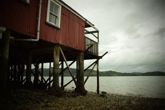 A shack built on a precarious pier out over the seaside