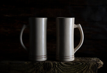 Two ceramic mugs on an old wooden board