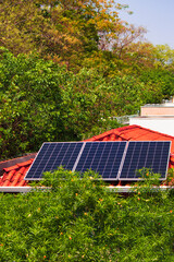 Solar panels on the red roof house in a sunny and cloudy day. Photovoltaic Solar Energy Instalation concept image.