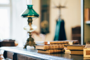 interior of an old house cabinet with books, wooden furniture and lamp