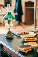 interior of an old house cabinet with books, wooden furniture and lamp