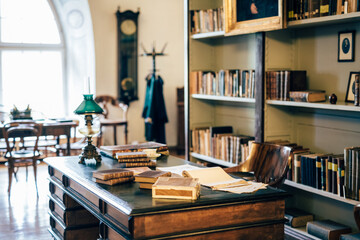 interior of an old house cabinet with books, wooden furniture and lamp