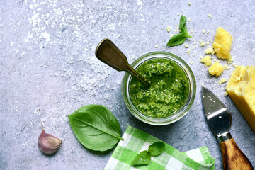 Traditional italian pesto - sauce from basil, cheese, garlic, nuts and olive oil. Top view with copy space.