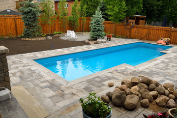 Newly installed swimming pool in Spring with unfinished, back yard landscaping construction ongoing - obrazy, fototapety, plakaty
