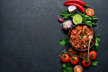 Tomato salsa (salsa roja) - traditional mexican sauce  with ingredients for making .Top view with copy space.