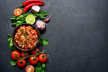 Tomato salsa (salsa roja) - traditional mexican sauce  with ingredients for making .Top view with copy space.