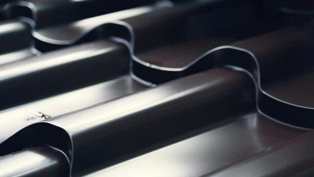 Metal tile for roof in metal forming machine production line close up. Industrial background.