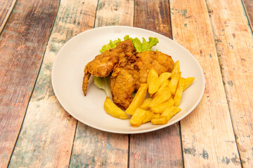 Kentucky-style breaded chicken garnished with homemade chips on wooden table