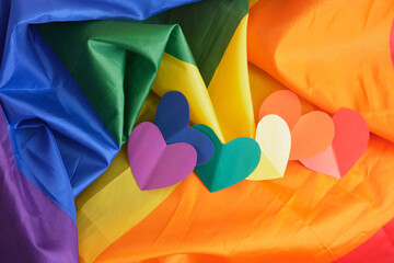 homemade paper hearts in the colors of the lgbt community pride flag on a large fabric flag