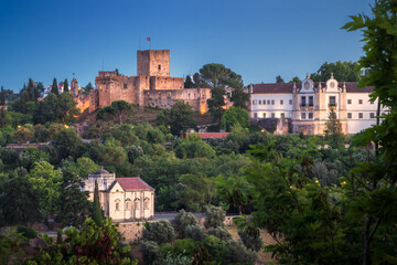 Fototapeta na wymiar View at dusk of the castle of Tomar with the Convent of Christ on the side and the Chapel of Nossa Senhora da Conceição below, in Tomar, Portugal.