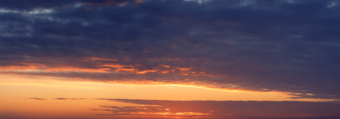 Dramatic sunset, the sun's rays shine through the clouds.