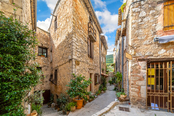 Fototapeta na wymiar Homes and shops inside the narrow alleys and winding streets of the medieval stone village of Tourrettes Sur Loup in Southern France.