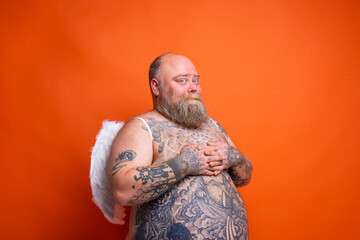 Fat man with beard ,tattoos and wings acts like an angel