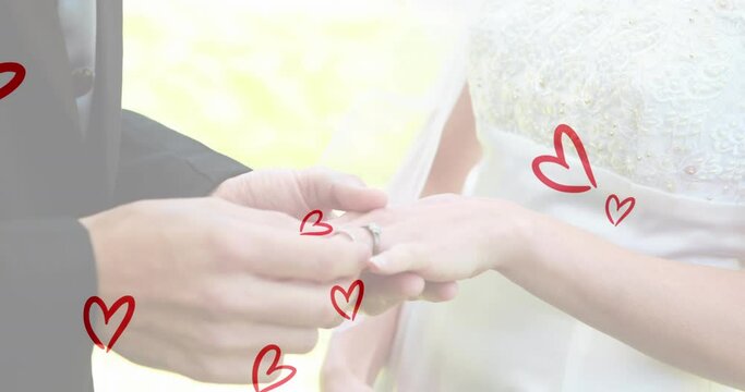 Animation of red hearts over caucasian couple wearing rings