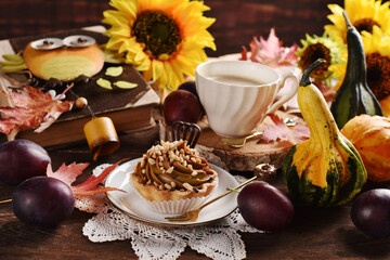 Fall still life with a cupcake and coffee and seasonal decors