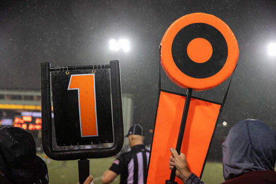 American football 1st down marker on rainy game day sideline on the field