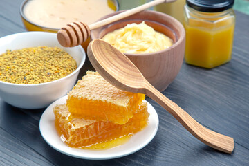 Fresh flower honey of different varieties, pollen and honeycomb with spoons on a wooden background. Organic Vitamin Health Food