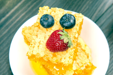strawberries, holubika lies on fresh honeycomb. vitamin organic food
