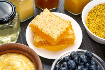 fresh assorted honey and blueberries on a wooden background. healthy organic vitamin food.