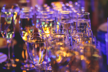 Line of alcohol setting on catering banquet table, bartender pouring beverages, row of different colored alcohol cocktails on a party, martini, vodka, and others on decorated banquet table event