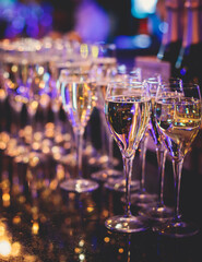 Line of alcohol setting on catering banquet table, bartender pouring beverages, row of different colored alcohol cocktails on a party, martini, vodka, and others on decorated banquet table event