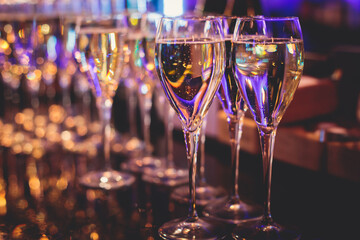 Line of alcohol setting on catering banquet table, bartender pouring beverages, row of different colored alcohol cocktails on a party, martini, vodka, and others on decorated banquet table event