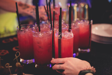 View of alcohol setting on catering banquet table, row line of red colored alcohol cocktails on a party, martini, vodka, spritz and others on decorated catering banquet table event