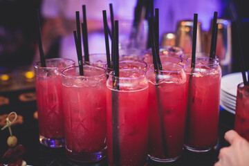 View of alcohol setting on catering banquet table, row line of red colored alcohol cocktails on a...