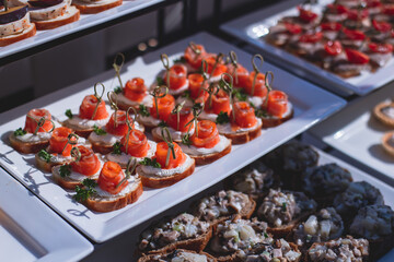 Catering table, beautifully decorated banquet with variety of with different food snacks and appetizers on corporate birthday party event or wedding celebration, seafood, canape, delicatessen setting