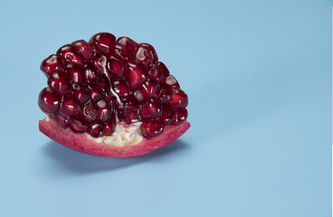 Close up of sliced pomegranate on blue background