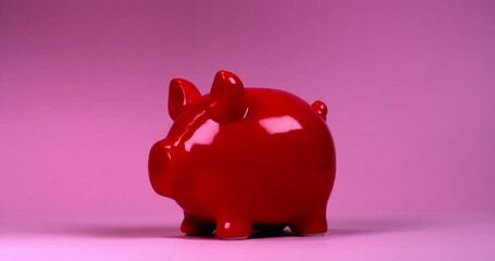 A hammer breaks a piggy bank shards and coins fly in different directions