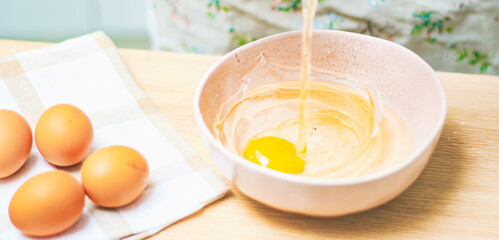 Broken egg in a bowl to mix with other baking ingredients