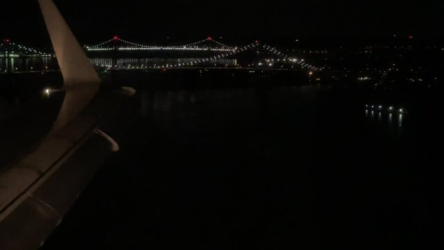 airplane landing in LaGuardia Airport with Bridge at night in New York City NYC
