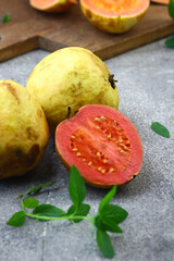 Naklejka na ściany i meble Guava fruit or Psidium Guava on wooden chopping board , on grey grainy background. 