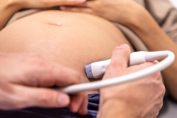 A doctor examinates a pregnant woman with ultrasonic testing