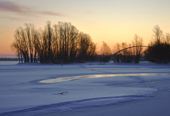 The frozen Bank of the Ob with trees and a bridge