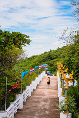 Woman with background of Chong Isariyabhorn (Chong Kao Kad) or Cape Maha Vajiravudh famous beach sunset point in Si chang island, Chonburi, Thailand.