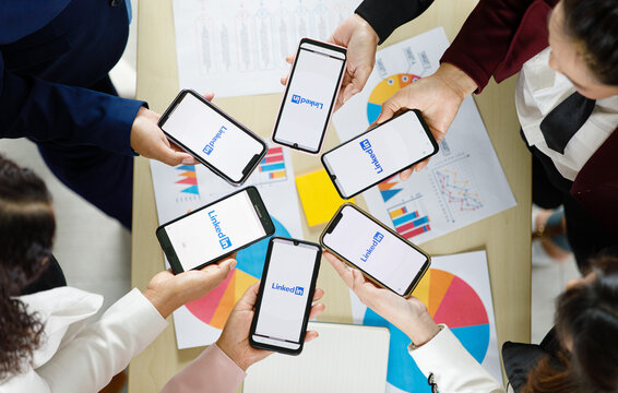 Bangkok/Thailand - August 06, 2021: People hold smartphones in different brands and various operating systems with logos of LinkedIn, social applications