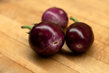 Indian purple eggplants on a wooden cutting board