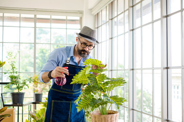 An elderly man handsome with have mustache wearing glasses is happy with tree care. is a hobby of gardening at home, living happily after retirement. Concepts nature and environment