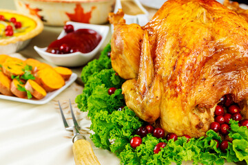 Thanksgiving dinner table with roasted turkey with cranberry sauce and yam.