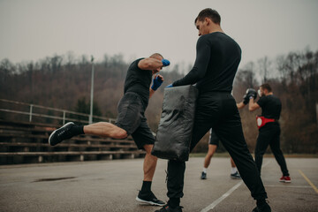 Man training kick box with his professional trainer