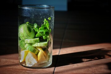assorted fruits and vegetables in a glass jar in the sun