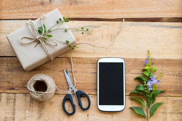 mobile phone with box package prepare send to customer by post office arrangement flat lay style on background wooden