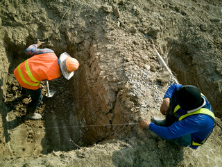 two workman is digging and sitting on ground soil, worker is dig for footing work, top view of labor shovel to dig a hole for foundation